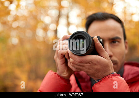 Attraktive inder Aufnehmen von Bildern mit einer spiegellosen Kamera durch den Wald im Herbst in Kanada Stockfoto