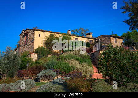 Typische italienische ländliche Haus mit Restaurant in üppiger Vegetation am Nachmittag im Sommer. Stockfoto