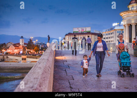 SKOPJE/Mazedonien - 28. AUGUST 2018: Leute über Steinerne Brücke Spaziergang am Abend, zu und von den Alten Basar und Mazedonien entfernt. Stockfoto