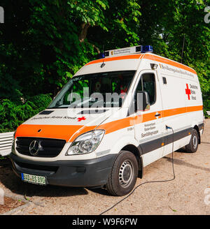 Baden-Baden, Deutschland - Apr 7, 2019: Deutsches Rotes Kreuz Transporter Mercedes-Benz Sprinter in den öffentlichen Park während der Hitzewelle geparkt Stockfoto