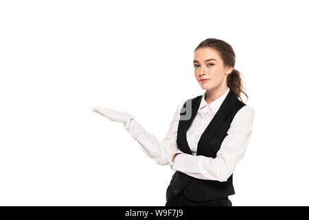 Junge Kellnerin in formale Abnutzung und weiße Handschuhe zeigt mit Hand isoliert auf weiss Stockfoto