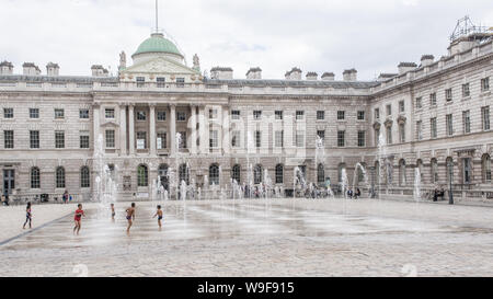 London, England - Mai 2019: Kinder spielen mit Wasser Brunnen im Hof von Somerset House, London, Großbritannien Stockfoto