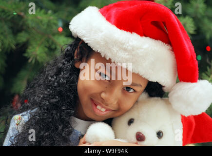 Mädchen, die einen weihnachtlichen Teddybären halten Stockfoto