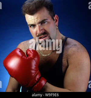 Bärtiger Mann in roten Boxhandschuhen Stockfoto