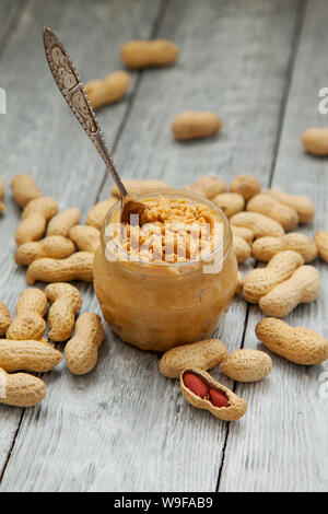 Eine offene Glas Erdnussbutter mit Löffel auf dem hölzernen Tisch Stockfoto