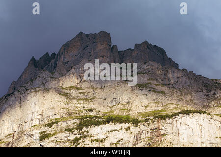 Dunkle felsigen Gipfeln an bewölkten Himmel. Licht und Schatten auf die Rocky Mountains. Hohe Berge close-up Hintergrund. Alpen in der Schweiz. Stockfoto