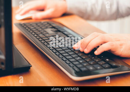 Mann mit Computer, kaufen online, suchen Informationen oder zu Hause arbeiten. Soft Focus Bild Farbe sortiert Stockfoto