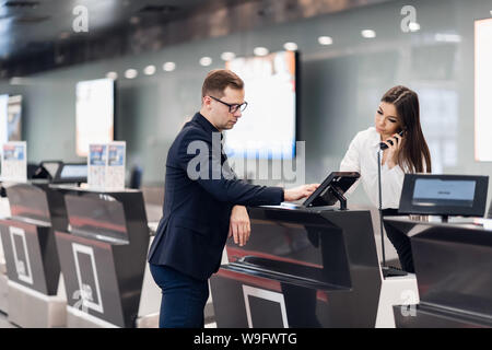 gut aussehend Geschäftsmann Übergabe Flugticket bei Airline Check-in Schalter Stockfoto