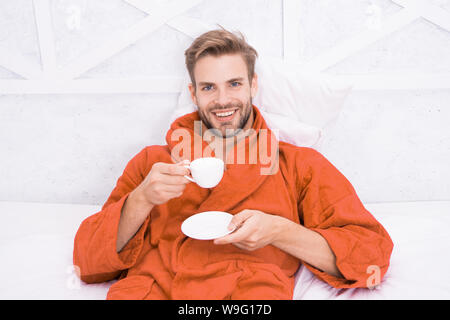 Kaffee am Morgen genießen. Gerne morgen. Schöner Mann trinken Kaffee am Morgen. Happy bärtiger Mann im Bett. Gute Laune. Ab Tag mit guten Kaffee. Entspannt zu Hause. Angenehme Momente. Gourmet Espresso. Stockfoto