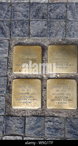 Plaketten in Plasterungen über Prag zum Gedenken an einzelne Opfer des Holocaust. Ein Mann geht in der Stadt täglich reinigen Stockfoto