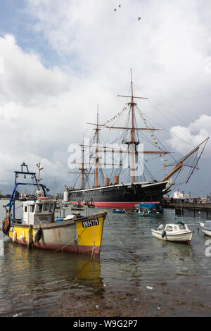 HMS Warrior angedockt in Portsmouth mit Fischerbooten im Vordergrund. Stockfoto