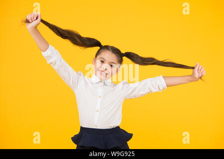 Schülerin Schüler lange Haare cute Pferdeschwänze Frisur. Pädagogisches Programm. Adorable Schulmädchen. Homeschooling oder besuchen regelmäßig die Schule. Die Effizienz des Studiums. Emotionaler Ausdruck Schulmädchen. Stockfoto