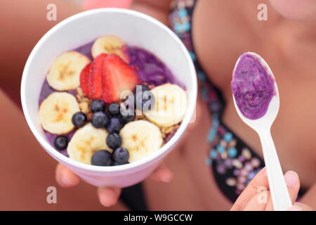 Acai Schüssel. Person essen acai Schüssel. Fokus auf Löffel. Stockfoto