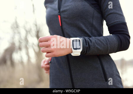 Smartwatch Frau läuft mit Pulsmesser. Nahaufnahme der weiblichen Handgelenk tragen smart Sportuhr als Activity Tracker im Freien während cardio Workout. Stockfoto