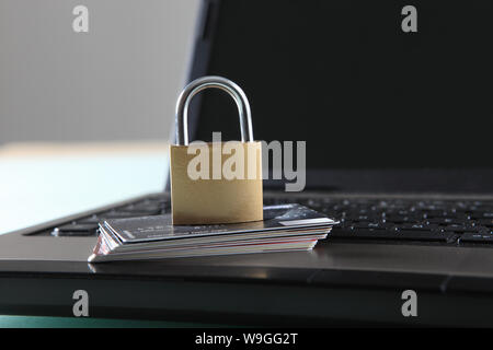 Schloss und Stapel von Kreditkarten auf laptop Stockfoto