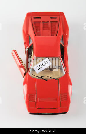 Spielzeugauto mit verkauften Schild an der Windschutzscheibe Stockfoto