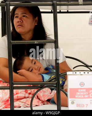 (190814) - Peking, Aug 14, 2019 (Xinhua) - eine Mutter kümmert sich um ihre kranke Kind, wie sie mit anderen Dengue-fieber Dengue-fieber-Patienten in einem Notfall medizinische Einheit durch das philippinische Rote Kreuz in Cavite Provinz, die Philippinen, 13.08.2019 eingestellt. Am 12.08.18, von den Philippinen Abteilung der Gesundheit (DOH) erklärte das Dengue-fieber Ausbruch eine nationale Epidemie nach einer Schwankung von Dengue Fälle und Todesfälle im Land. Die Abteilung hat rund 146.000 Fälle von Dengue-fieber von Januar bis Juli 20 in diesem Jahr, 98 Prozent mehr als im gleichen Zeitraum im Jahr 2018 verzeichnet. Der Ausbruch verursacht hat 622 Todesfälle, fügte es hinzu. (Xinh Stockfoto