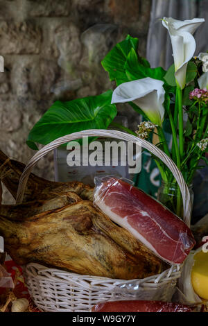 Ganzen Schinken mit Knochen Bein des montenegrinischen Njeguski prsut Schinken ähnlich wie Schinken und geschnittenes verpacktes Fleisch auf dem Markt in Kotor, Montenegro Stockfoto