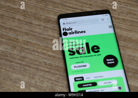 Flair Airlines Website auf ein Android Handy, während auf einem Tisch platziert. Stockfoto
