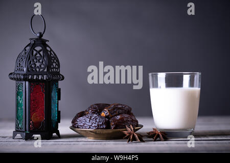 Ramadan Essen und Getränke Konzept. Ramadan Termine Laterne mit Milch, Obst auf hölzernen Tisch Hintergrund. Stockfoto