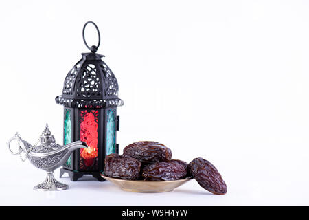 Ramadan Essen und Getränke Konzept. Ramadan Laterne mit arabischen Lampe, Holz Rosenkranz, Termine Obst und Beleuchtung auf weißem Hintergrund. Stockfoto