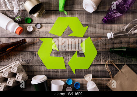 Blick von oben auf die verschiedenen Müll Materialien mit Recycling Symbol auf Tisch Hintergrund. Recycling, Umwelt und Eco-Konzept Stockfoto
