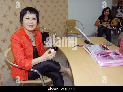 Frau Yue-Sai Kan, Gründer von Yue-Sai Kosmetik, schmiert Salbe Mücken, die im Verlauf der Veranstaltung für die Förderung ihrer Bücher Die komplette chinesische Frau zu verhindern Stockfoto