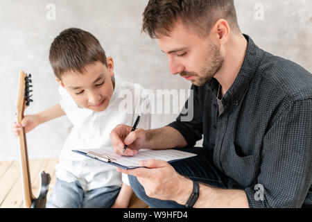 Nach Tutor seiner jungen Schüler neue Musik Lektion mit E-Gitarre bereiten Esprit. Stockfoto