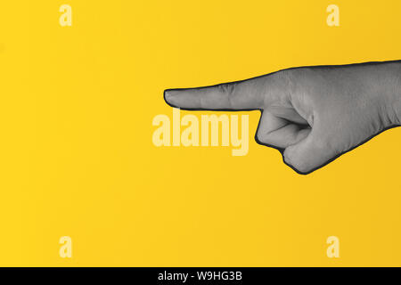 Schwarze und weiße Frau Hand zeigen. Isolierte Bild auf gelben Hintergrund. Surrealistisches Element für Design, Plakate und Banner. Magazin Stil. Stockfoto