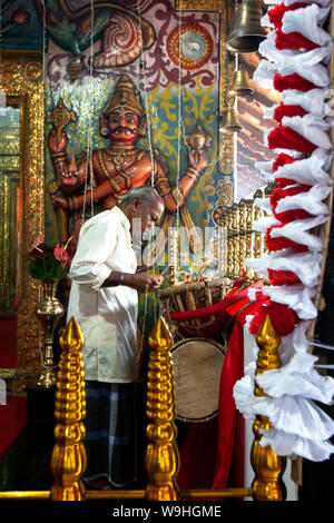 Ein Mann spielt eine thammattam am Eingang des hinduistischen Diety Kataragamas Schrein innerhalb der Kataragama Tempel bei Kandy in Sri Lanka drum. Stockfoto