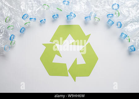 Rahmen von gebrauchten Kunststoffflaschen mit Recycling Symbol auf Holz- Hintergrund. Recycling Konzept Stockfoto