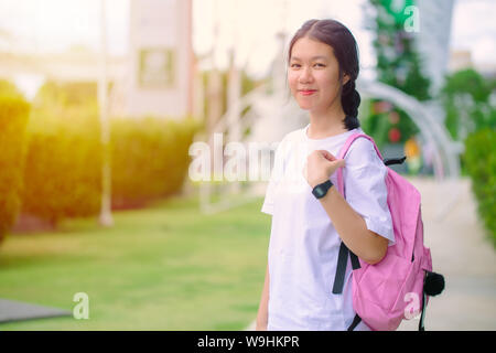 Asiatische Thai Teenager Schule Mädchen mit Bildung Tasche stehend Outdoor glücklich und Lächeln. Stockfoto