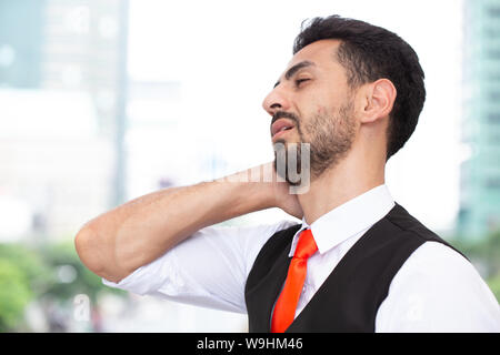 Latin Geschäftsmann Hals Schmerzen, Erschöpfung von harter Arbeit Büro Syndrom Stockfoto