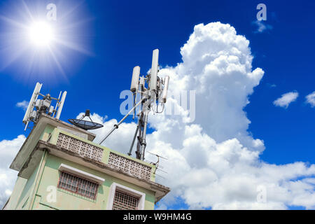 Telefon Kommunikation Turm Zelle Aufstellungsort Wurzel oben auf Gebäude mit blauem Himmel Hintergrund Stockfoto