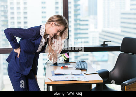 Business Frauen Hand an der Rückseite Taille schmerzhaft von Nierenerkrankungen beim Arbeiten Tag im Büro Stockfoto