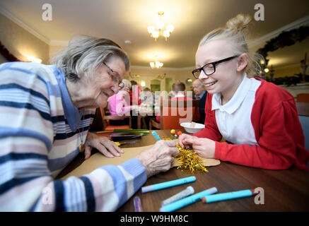 Schulkinder in der Bristol besuchen Pflegeeinrichtungen zu Weihnachten Dekorationen machen mit Bewohnern in einer Regelung, die von der Nächstenliebe lebendig Aktivitäten organisiert Stockfoto