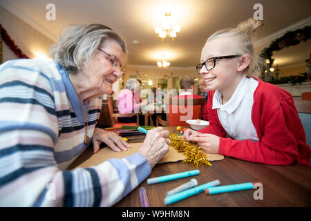 Schulkinder in der Bristol besuchen Pflegeeinrichtungen zu Weihnachten Dekorationen machen mit Bewohnern in einer Regelung, die von der Nächstenliebe lebendig Aktivitäten organisiert Stockfoto