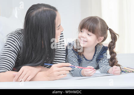 Glücklich liebende Familie Mutter und ihrer Tochter kind Mädchen spielen im Kinderzimmer. Lustige Mama und Kind gemeinsam Spaß zu haben. Stockfoto