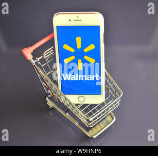 Jaroslawl, Russland - August 13, 2019: iPhone mit Walmart Logo in mini Warenkorb auf Tisch. Stockfoto