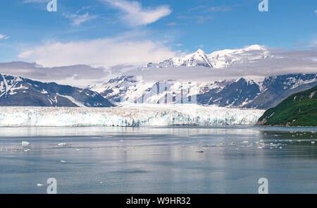 Ein Teil der Fläche des Hubbard Gletscher in der Yakutat Bay in Alaska mit der St. Elias Berge und schöne Wolken im blauen Himmel im Hintergrund Stockfoto