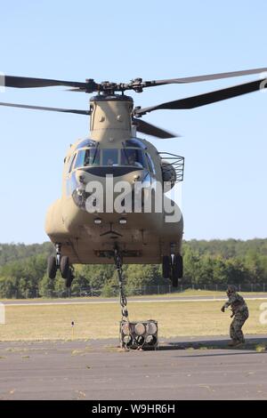 Schüler der 89 B Munition liefern Kurs verbinden ein mock Munition Palette zu einem CH-47 Chinook Hubschrauber Aug 1, 2019, als Teil der Schlinge - last Ausbildung bei Sparta-Fort McCoy Flughafen am Fort McCoy, Wis die Chinook und die Crew sind ab dem 7. Bataillon, 158 Aviation Regiment des neuen Jahrhunderts, Kansas. Die Munition liefern, von der 13 Bataillon gelehrt, 100 Regiment am Fort McCoy, ist einen 4-wöchigen Kurs, der eine Schulung für die Soldaten, die Umgliederung der 89 B militärische berufliche Spezialität sind. Die Schlinge - last Training ist einer der letzten großen Ausbildung Veranstaltungen während des Kurses. Ein s Stockfoto