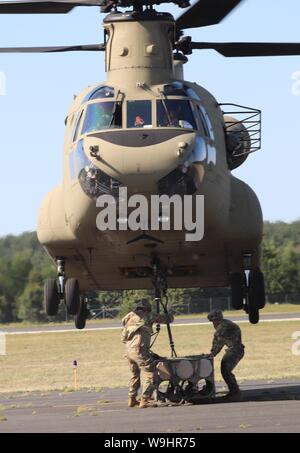 Schüler der 89 B Munition liefern Kurs verbinden ein mock Munition Palette zu einem CH-47 Chinook Hubschrauber Aug 1, 2019, als Teil der Schlinge - last Ausbildung bei Sparta-Fort McCoy Flughafen am Fort McCoy, Wis die Chinook und die Crew sind ab dem 7. Bataillon, 158 Aviation Regiment des neuen Jahrhunderts, Kansas. Die Munition liefern, von der 13 Bataillon gelehrt, 100 Regiment am Fort McCoy, ist einen 4-wöchigen Kurs, der eine Schulung für die Soldaten, die Umgliederung der 89 B militärische berufliche Spezialität sind. Die Schlinge - last Training ist einer der letzten großen Ausbildung Veranstaltungen während des Kurses. Ein s Stockfoto