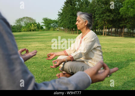 Altes Ehepaar sitzt im Yoga darstellen Stockfoto