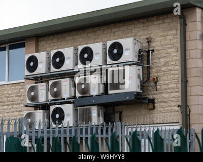 Eine Bank der Klimaanlage Kondensator einheiten auf einem Werk an der Wand montiert. England UK. Stockfoto