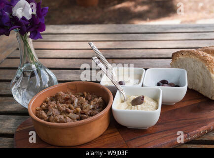 Vegane Gerichte von Saubohnen und Dips mit Brot im Garten Stockfoto