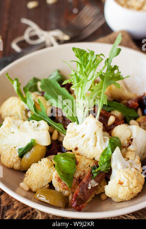 Gebratener Blumenkohl mit Oliven, getrocknete Tomaten, Pinienkernen und Basilikum. Gesunde Ernährung Stockfoto