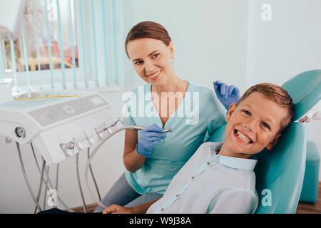 Süße Junge lächelnd während Zähne Prüfung. Happy Boy im Zahnarztstuhl sitzen und in Check up Zähne Stockfoto