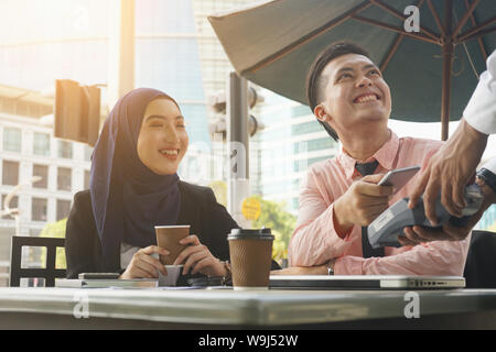 Malaiisch muslimischen Business Team mit QR ewallet Zahlung im Cafe Stockfoto