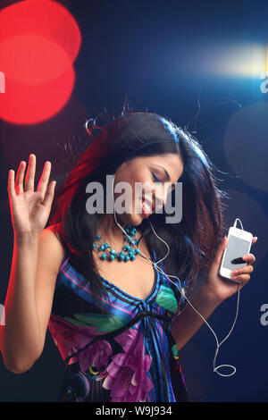 Frau anhören von Musik auf einen MP3-player Stockfoto