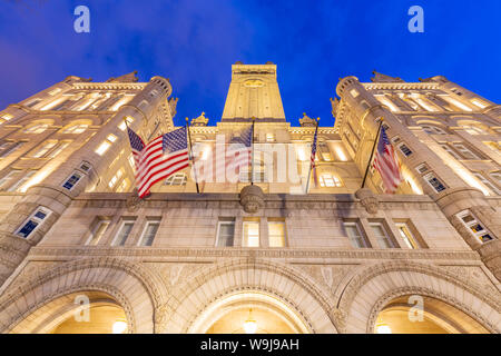 Blick auf die US-Flaggen vor dem ehemaligen Old Post Office Pavilion in der Dämmerung, Washington DC, District of Columbia, Vereinigte Staaten von Amerika Stockfoto